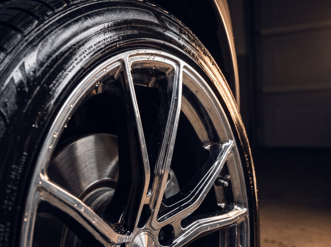 Chrome and black alloy wheel with tire dressing and visible brake caliper